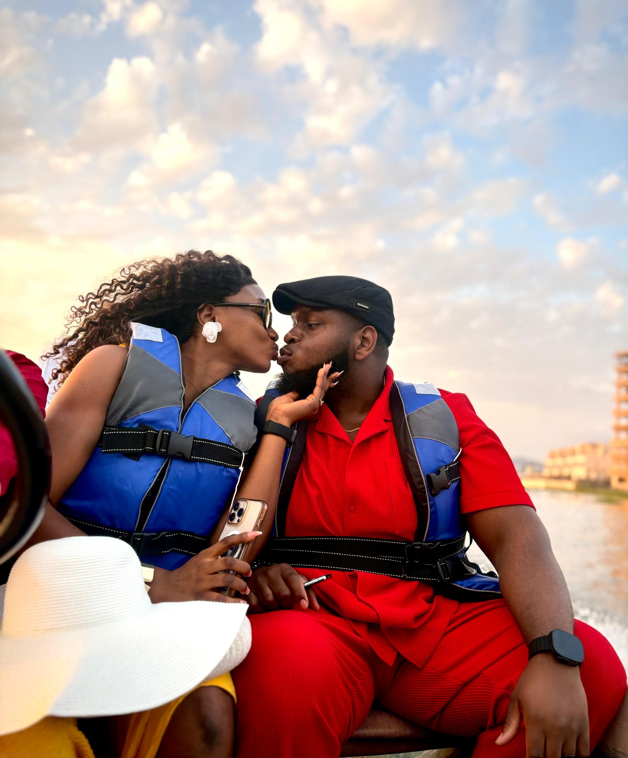 Gabrielle and Ifeanyi leaning in for a kiss by the lake