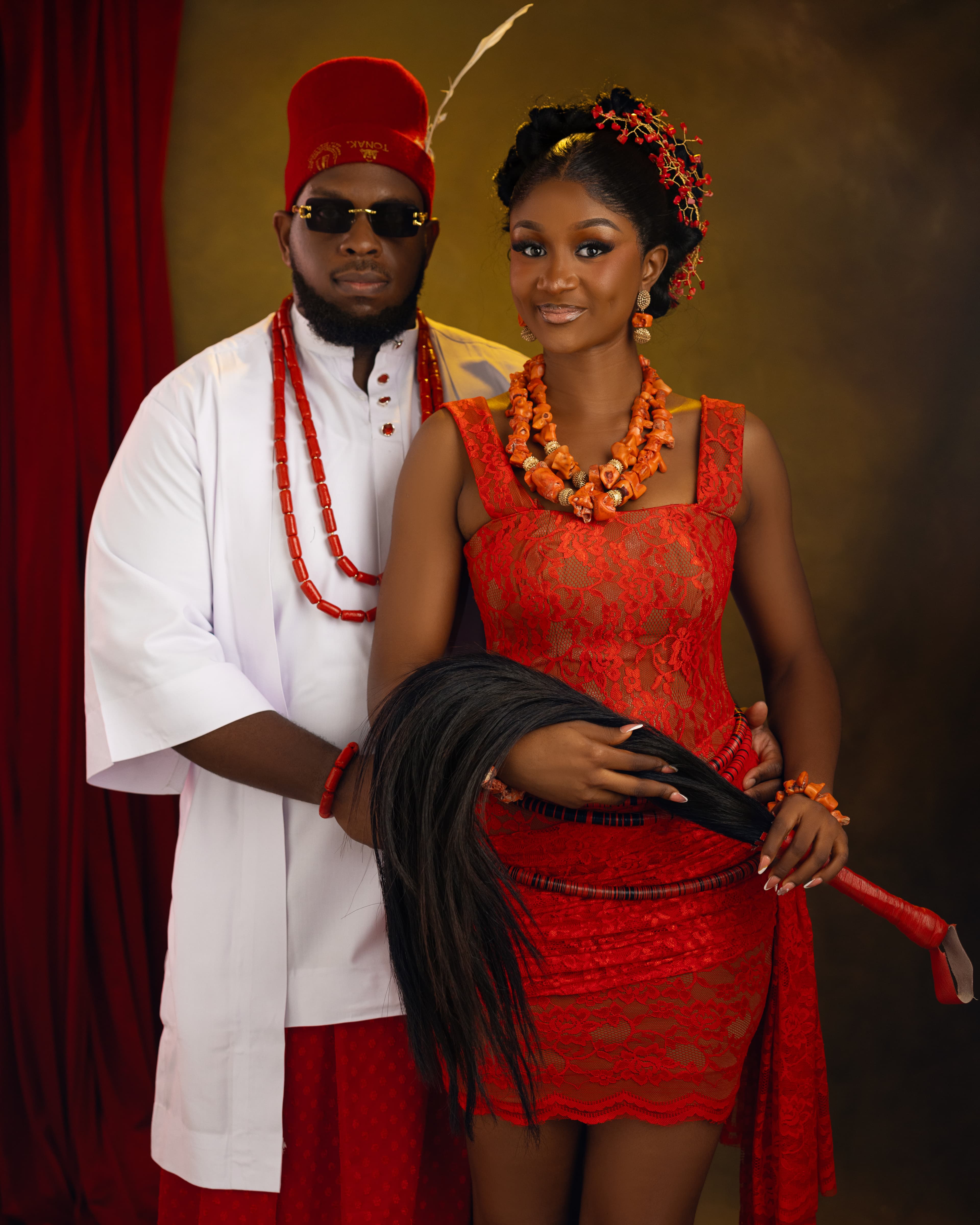 Ifeanyi and Gabrielle posing together in red and white traditional attire